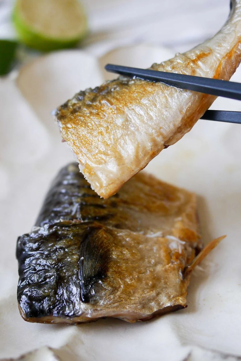 筷子夾起鯖魚肉，呈現魚肉細嫩多汁
