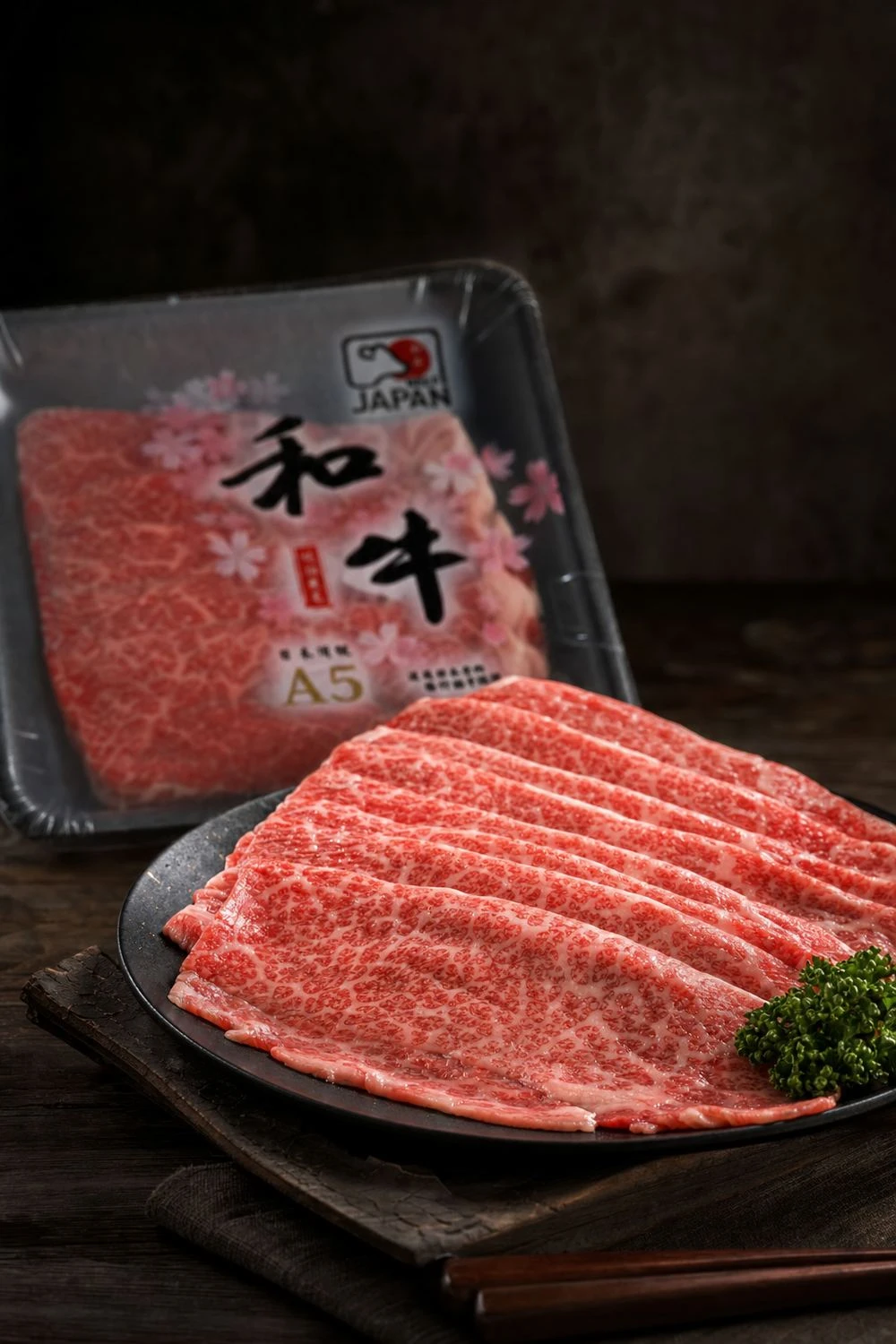 日本A5櫻花和牛真空盒裝,前景為擺盤雪花和牛薄片